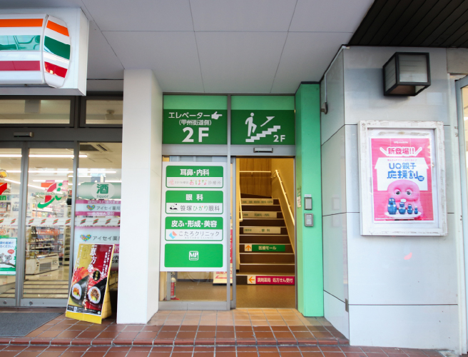 セブンイレブンとauの間に入口（A）がありますので、階段にてお上がりください。